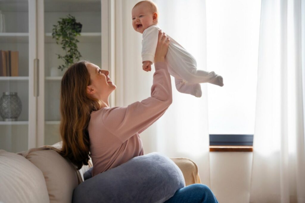 Femme épanouie portant son bébé dans ses bras, illustrant un moment de bien-être et mettant en valeur l'importance de l'accompagnement post-partum.