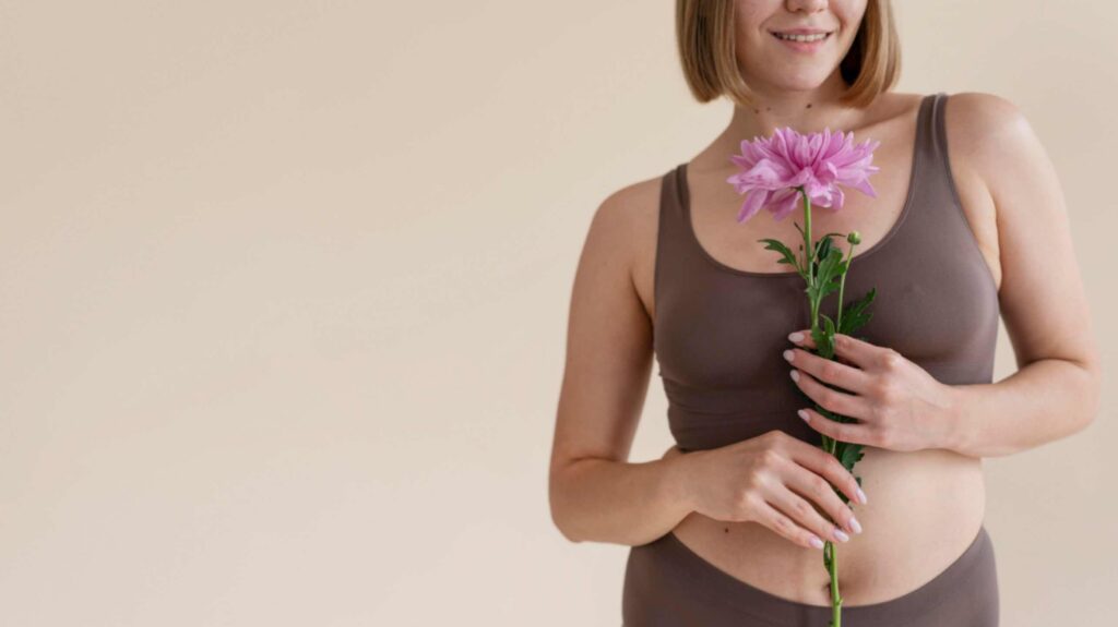 une femme heureuse qui tient une fleur entre ses mains heureuse d'avoir opté pour une contraception naturelle