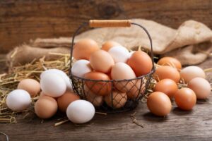 des œufs posé sur une table dans un panier, ce sont de bon aliments pour une alimentation post partum