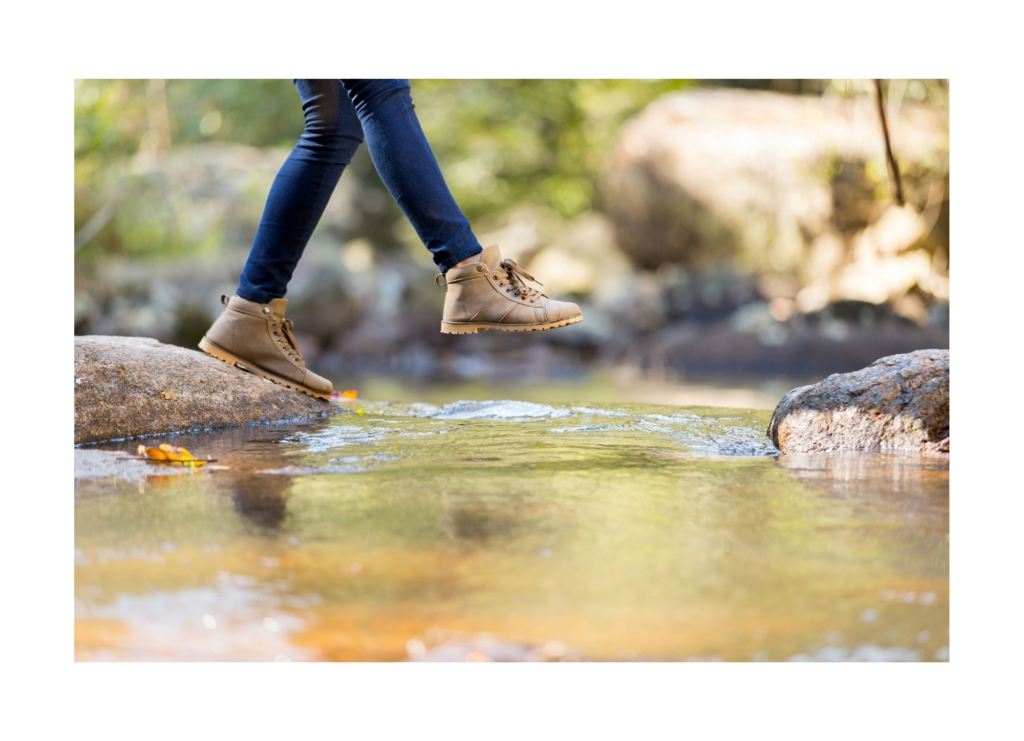 Conseillère en Symptothermie. Une formation en symptothermie représente une transition de vie, un changement significatif dans la vie d'une femme, tel que cette femme que l'on observe traverser un ruisseau. En effet, cela leur permet également de se reconnecter à leur corps de femme et de le connaître mieux.