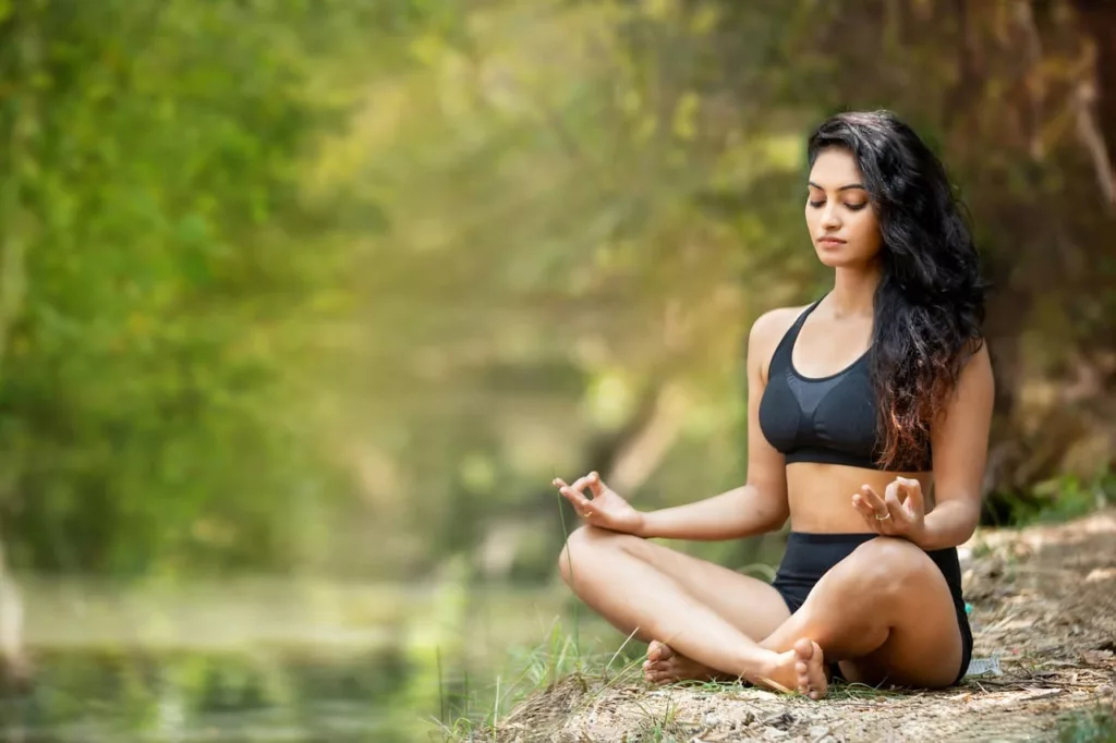 Une femme fait du yoga pour diminuer son niveau de stress et soigner naturellement l'endométriose, comme lui a recommander sa naturopathe.